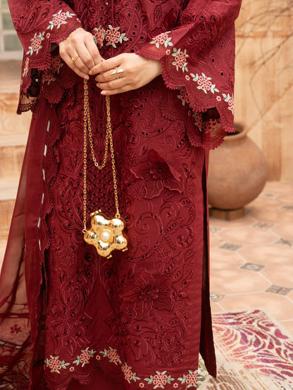 Close-up of maroon embroidered lawn suit with gold chain bag