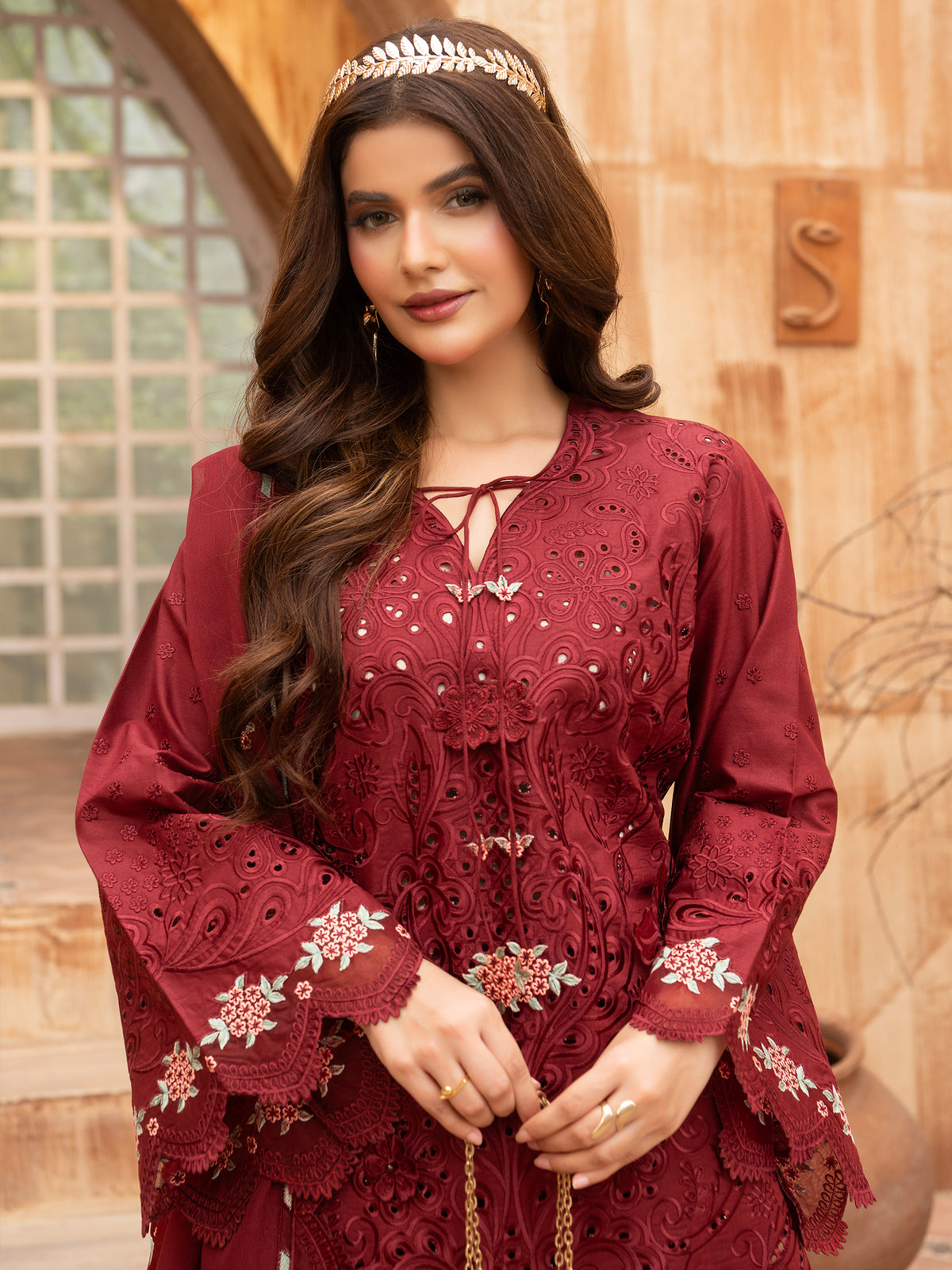 Seated pose wearing maroon embroidered lawn suit with intricate detailing