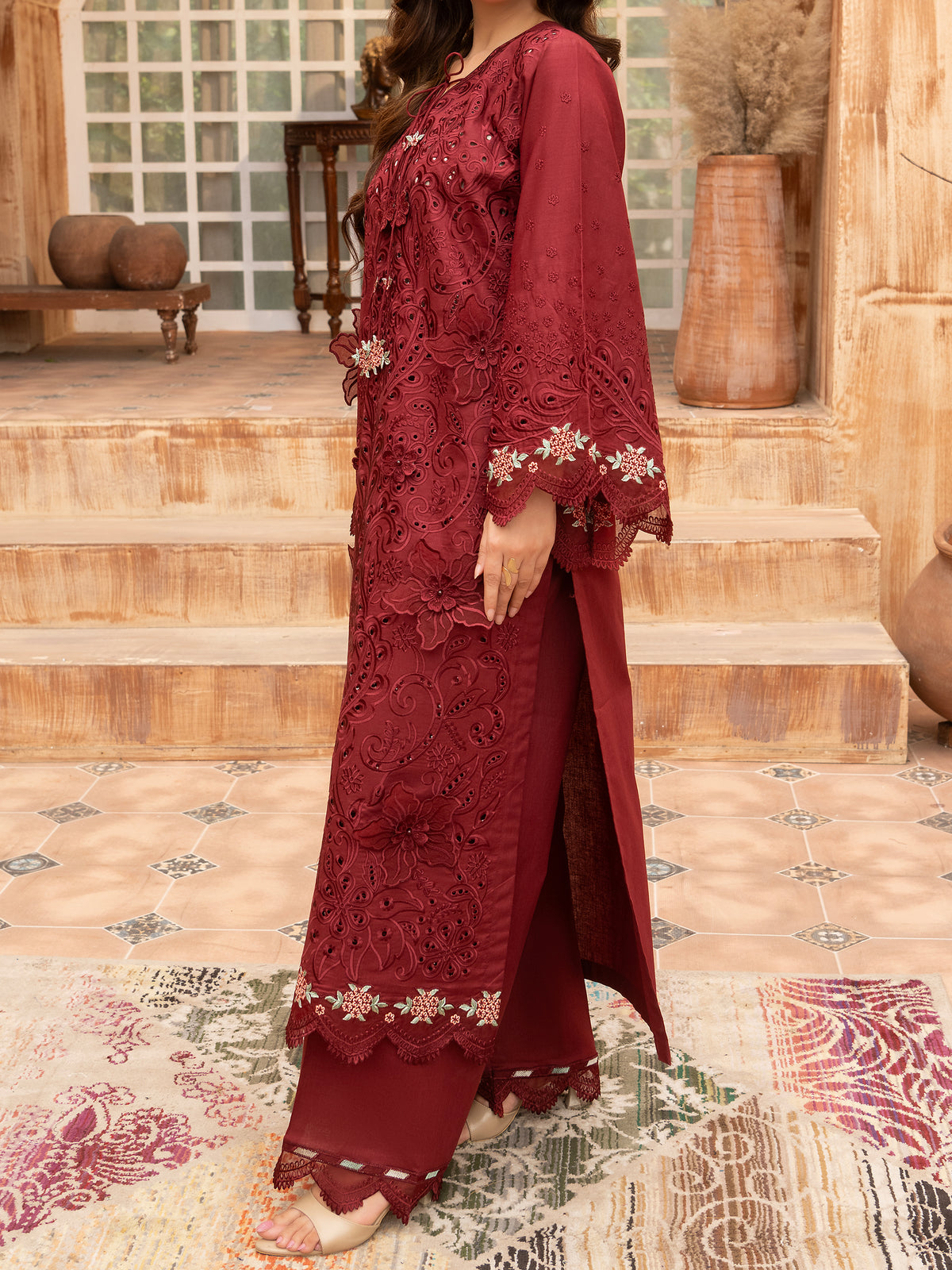 Side view of maroon embroidered lawn suit with lace hem
