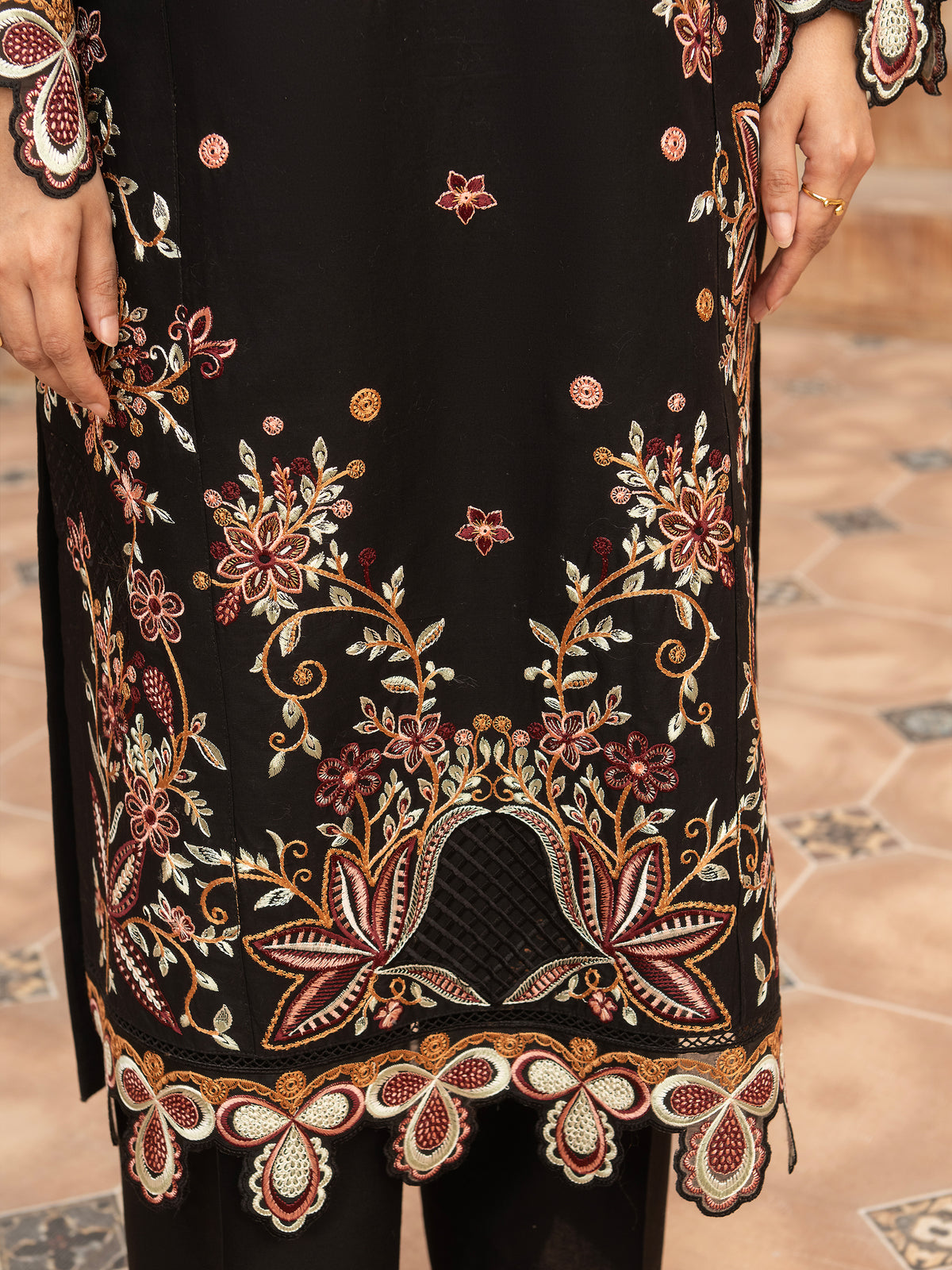 Close-up of embroidered hem on black lawn suit